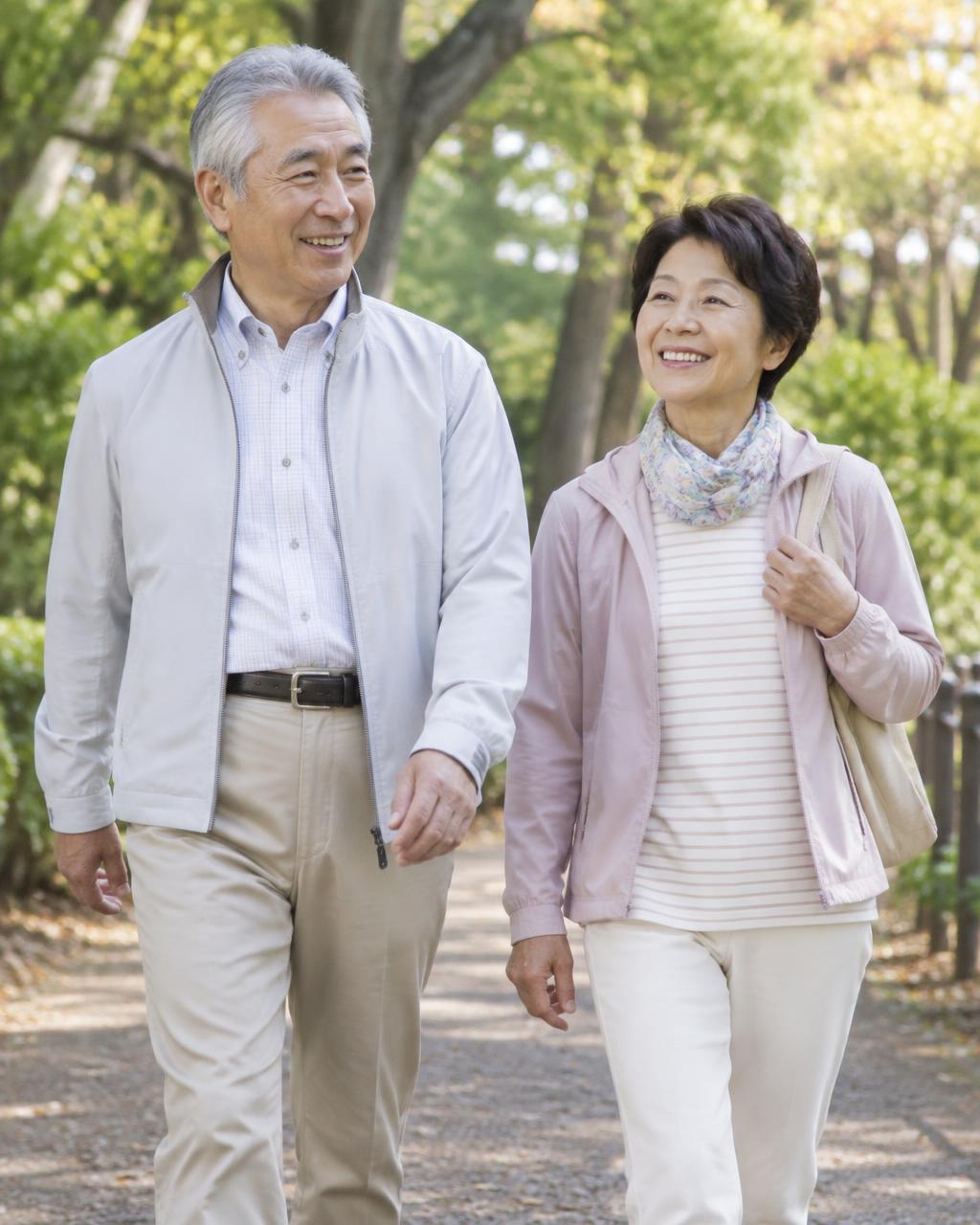 公園を歩く60代から70代の日本人夫婦